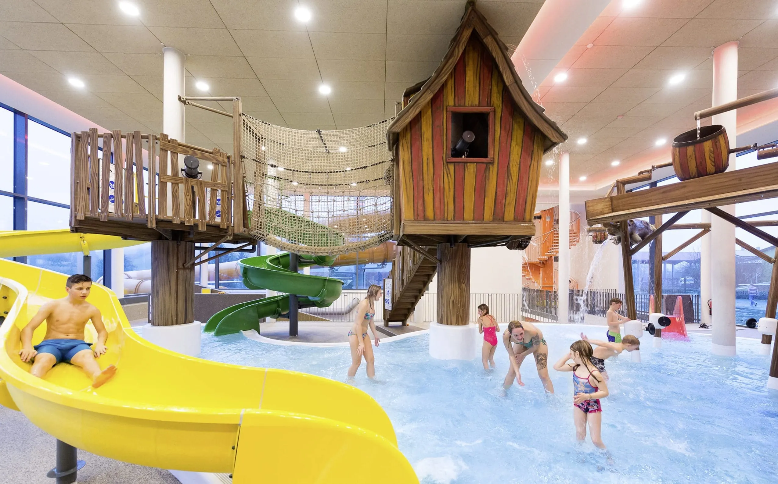 Holzhäuschen und Wasserrutsche im Kinderpoolbereich des Familienhotel Schreinerhof