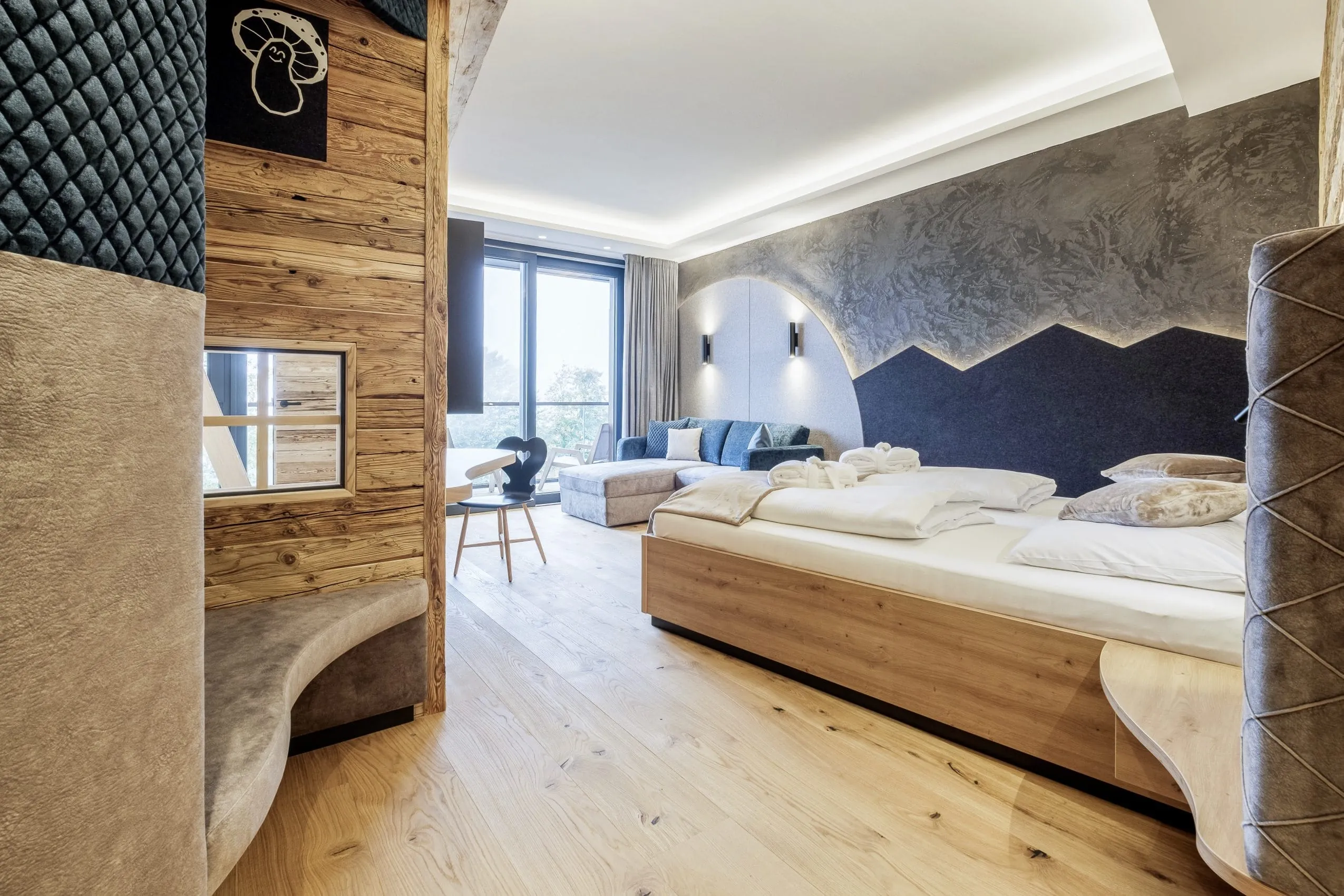 Familienzimmer im Familotel Allgäuer Berghof mit Bergpanorama an der Wand und Altholzwand
