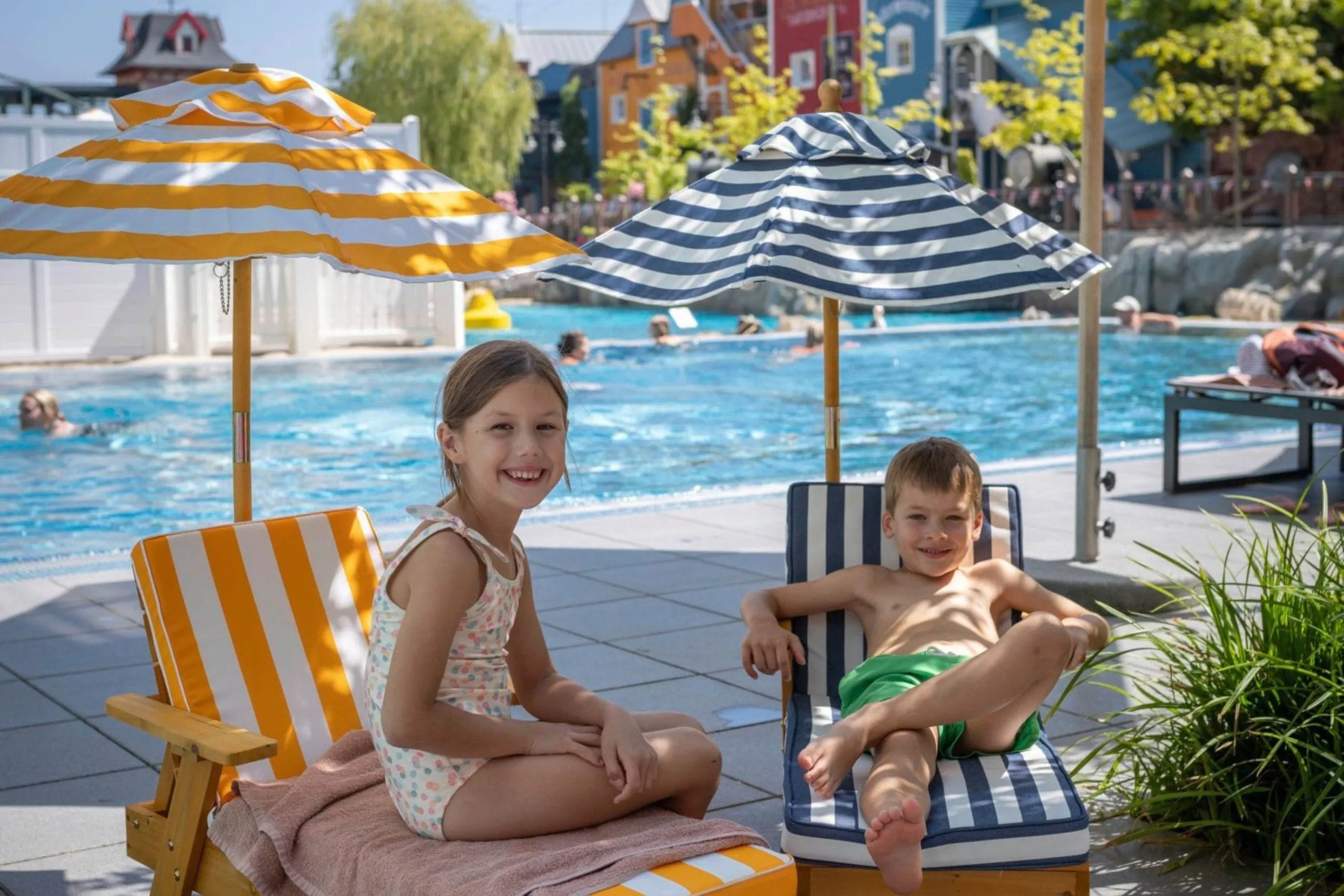 Zwei Kinder auf kleinen Kinderliegen am Outdoorpool des "Krønasår – The Museum-Hotel" zu sehen