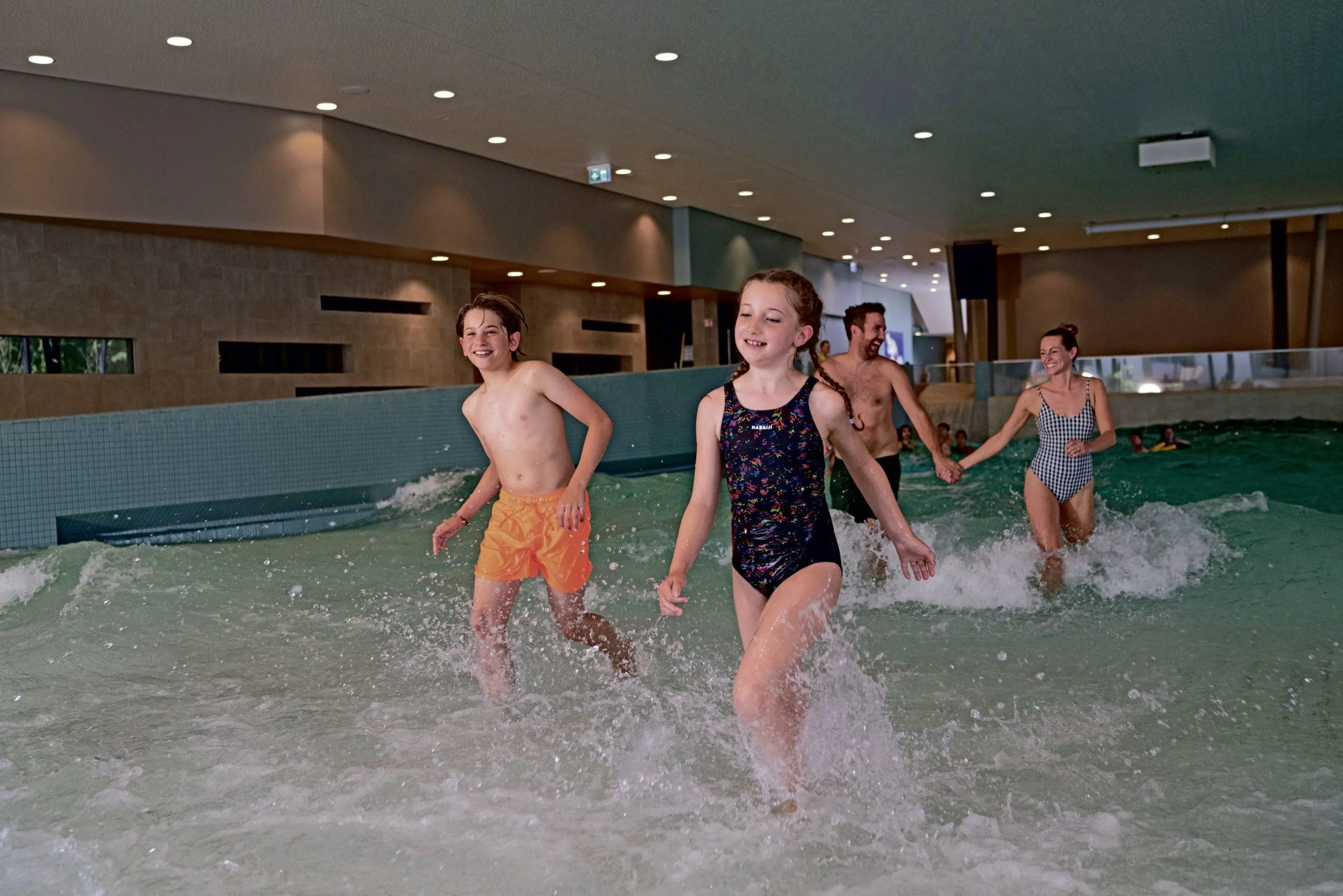 Eltern mit zwei Teenager-Kindern kommen aus dem Pool des Strandhotel Weissenhäuser Strand