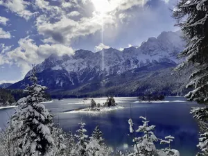 Eibsee im tiefen Winter vor schneebedeckten Gipfeln der Zugspitzregion