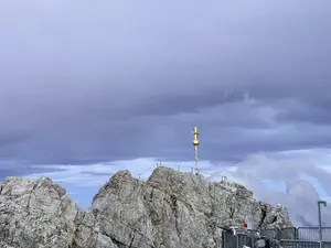 goldenes Gipfelkreuz auf der Zugspitze direkt gegenüber des Bayern Resorts
