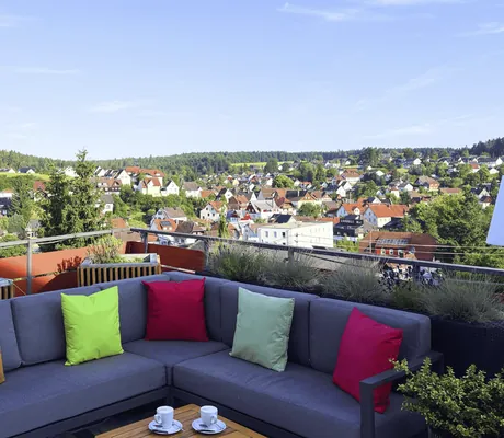 bunte Kissen auf Ecksofa auf der Dachterrasse mit Blick über den Ort vom Hotel Resort Waldachtal