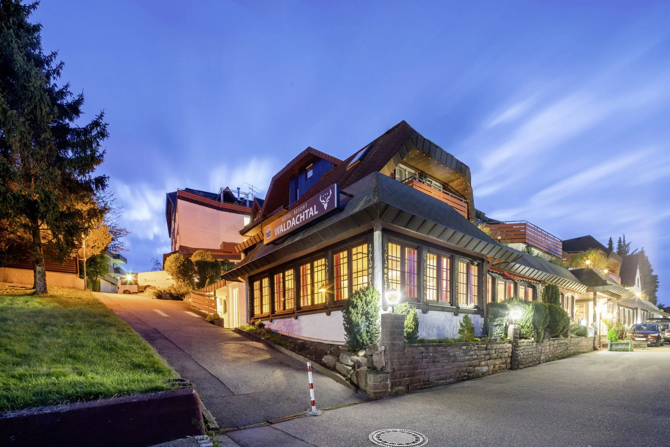 beleuchtete Einfahrt mit Bleiglasfenstern des Hotel Resort Waldachtal
