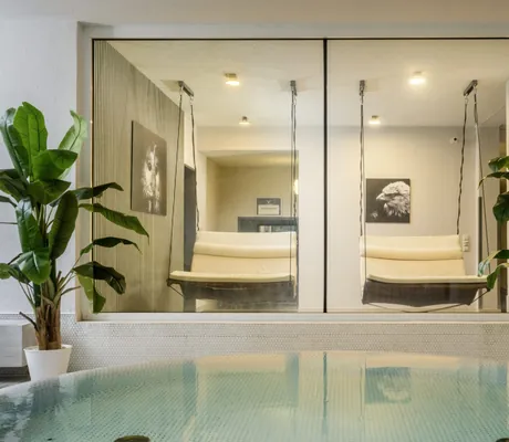zwei Schaukelliegen am Indoorpool mit Bananenpflanzen im Hotel Resort Waldachtal