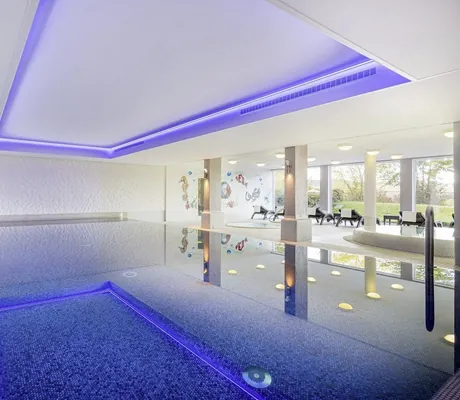 Indoorpool im Hotel Resort Waldachtal mit Mosaikfliesen und blau beleuchteter Decke
