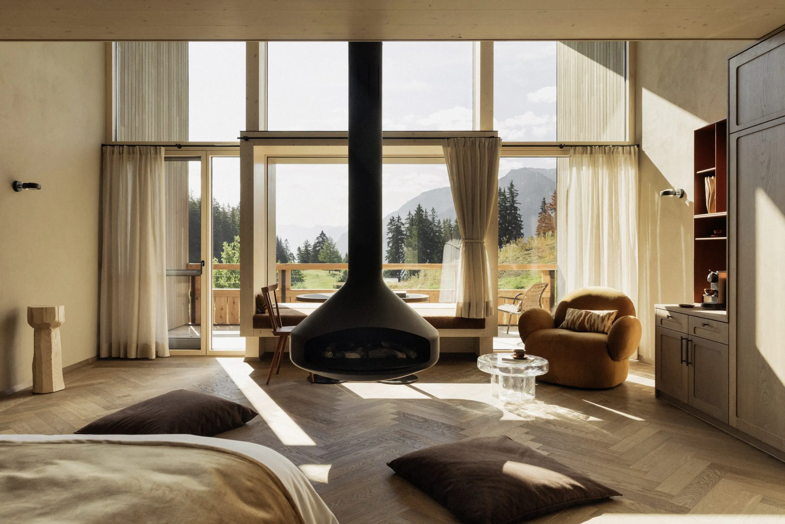Blick über den hängenden Kamin durchs Panoramafenster der Suite im Berghotel Schlossanger Alp